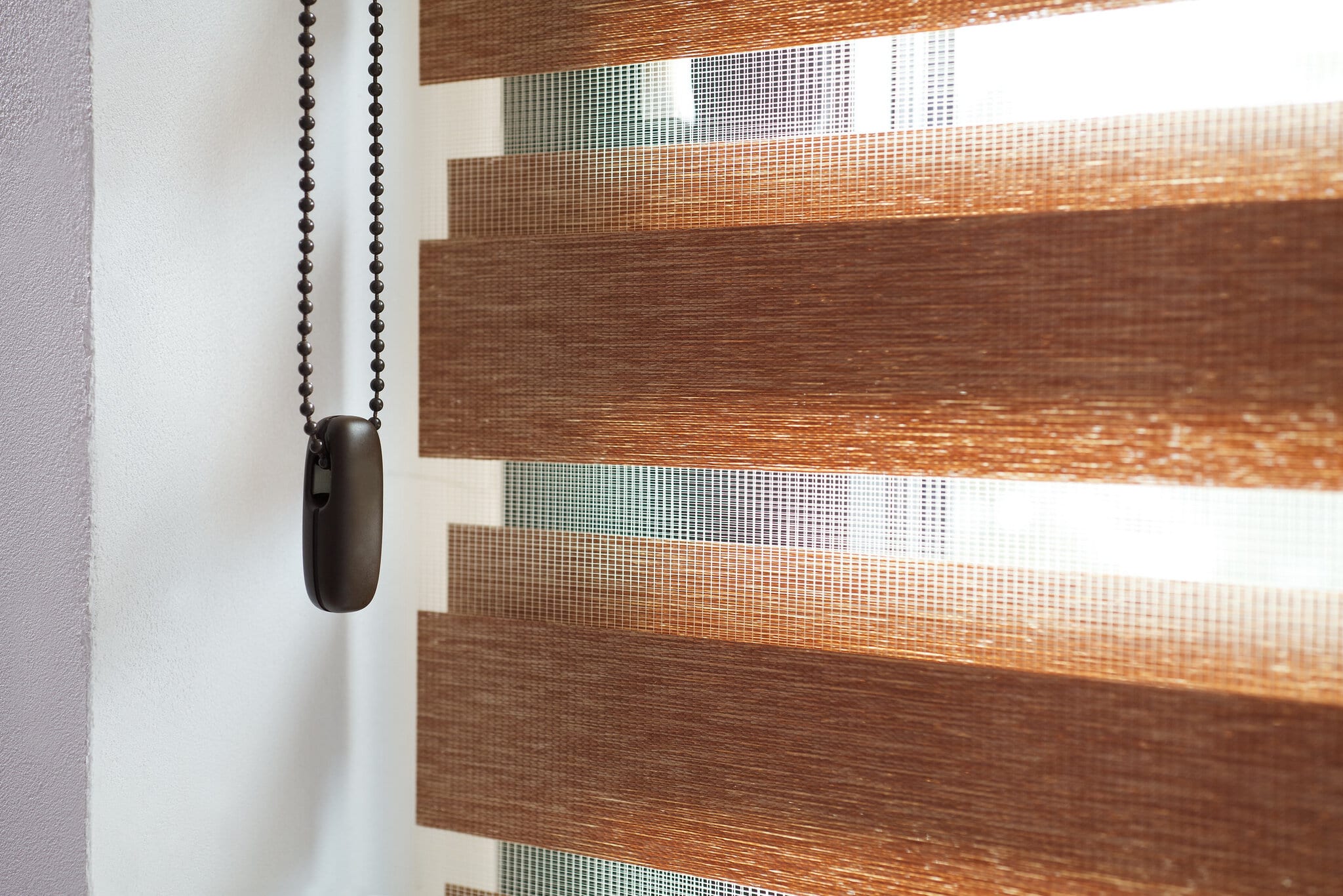 Doppelrollo im Detail Detailaufnahme eines Doppelrollos in Holzoptik mit Kettenzug