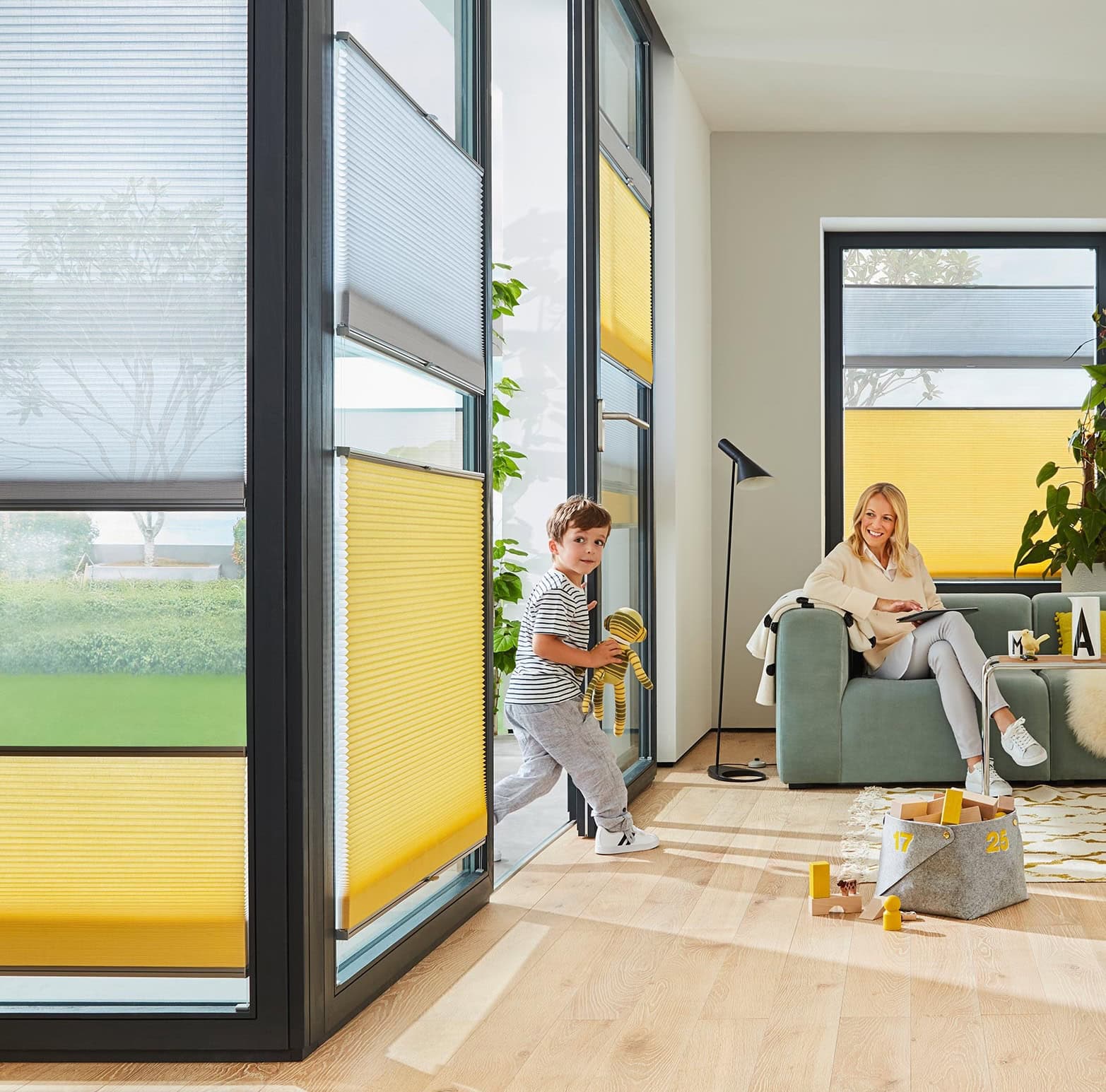 plissee-nach-mass-sonnenschutz-dorsten Wohnzimmer mit gelben Plissees an bodentiefen Fenstern als Sicht- und Sonnenschutz