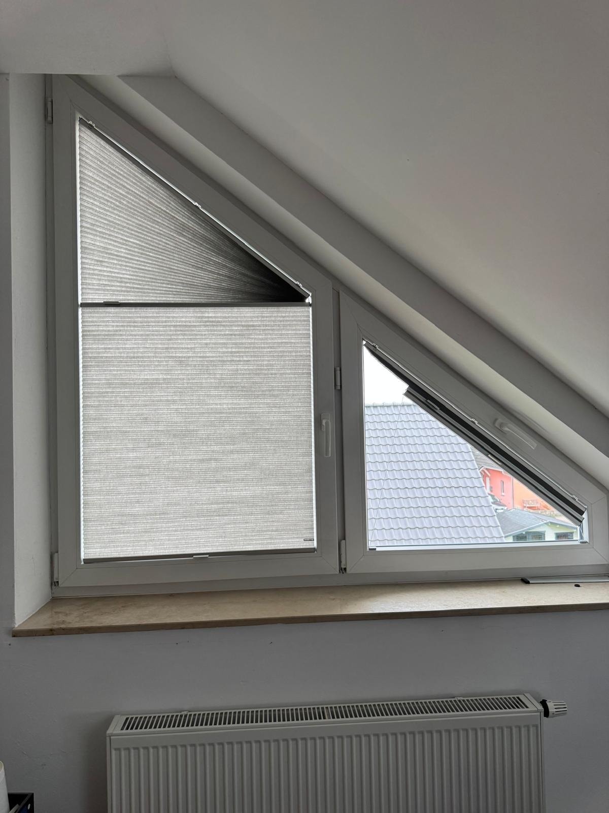 Plissee als Sicht- und Sonnenschutz an einem Fenster in der Dachschräge